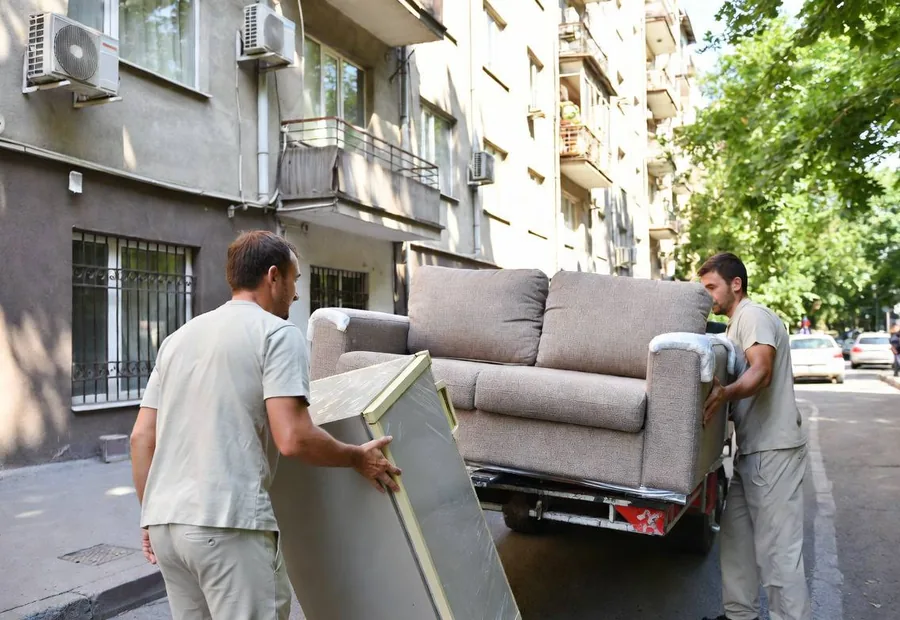 Movers carrying furniture near a building